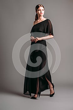 One shoulder ruffled maxi dress in black. Asymmetric open-back chiffon gown with a strap, split and frills photo
