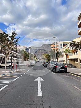 One side road with the road sign on it. Street with parallel parked cars.