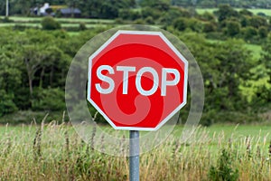One sign with a white word stop on a red background. Road sign. Red and white sign