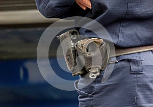 One single anonymous policeman, police officer in a blue uniform, equipment closeup, handcuffs, pepper spray detail up close.