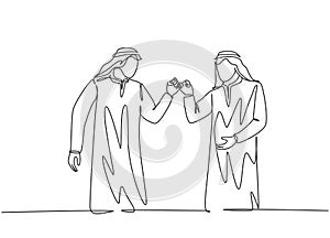 One single line drawing of young happy muslim workers fist bump their hands together. Saudi Arabian businessmen with shmag,