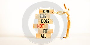 One size does not fit all symbol. Concept words One size does not fit all on wooden blocks. Businessman hand. Beautiful white photo