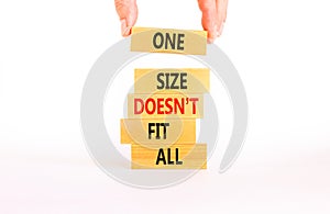One size does not fit all symbol. Concept words One size does not fit all on wooden blocks. Businessman hand. Beautiful white