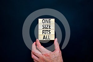 One size fits all symbol. Concept words One size fits all on wooden blocks. Businessman hand. Beautiful black table black