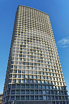 one skyscraper white building rises blue sky