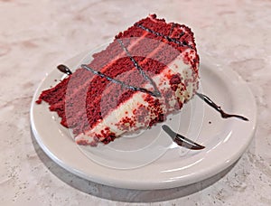 one slice of red velvet cake with chocolate drizzle photo