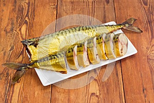 One sliced and one whole smoked Atlantic mackerel on dish