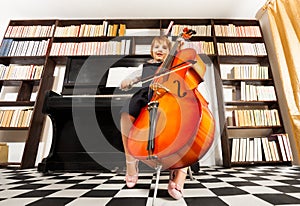 One small girl in uniform dress playing on cello