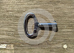 one small key on a wooden background top view photo