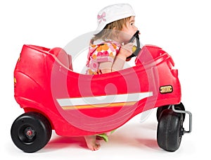 One small little girl playing with toy car.