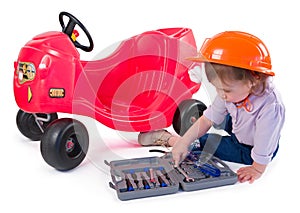 One small little girl repairing toy car.