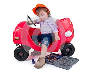 One small little girl repairing toy car.