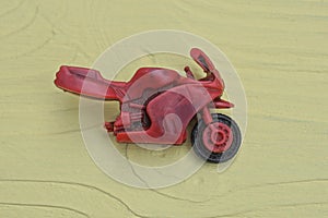 one small red plastic broken motorcycle toy