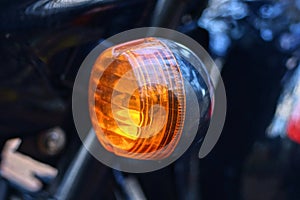 one small round red glass headlight turn signal on a black motorcycle