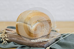 One white round bread with wheat fiber on the table.