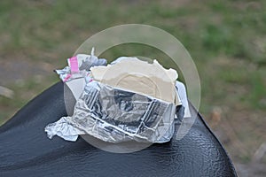 one small white piece of processed cheese in a gray foil package