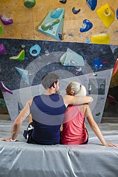 One Smiling Young Joyful couple Preparing To Bouldering climbing up the wall Together While Resting Together