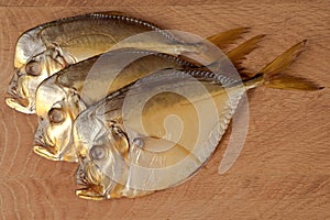 One smoked vomer fish on a white plate isolated