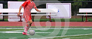 One soccer player dribbling the ball down the field