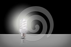 One spiral light bulb on black background