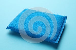 One sponge on light blue background, closeup