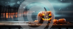 One spooky halloween pumpkin Jack O Lantern with an evil face and eyes on a wooden bench table with a misty gray coastal night