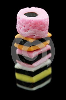 One stack of liquorice allsorts candy isolated on black background