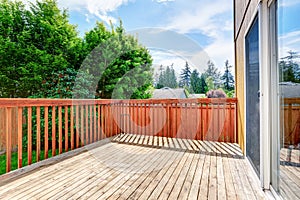 One story house with wooden walkout deck overlooking backyard garden