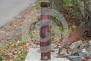 One striped iron fence post from an old rail