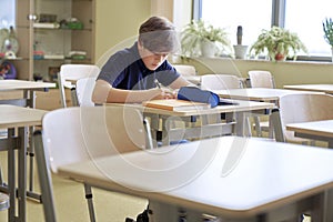 One student sitting and learning alone in empty classroom