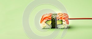 One sushi roll with chopsticks on the minimal green background. Japanese food restaurant delivery mockup. California