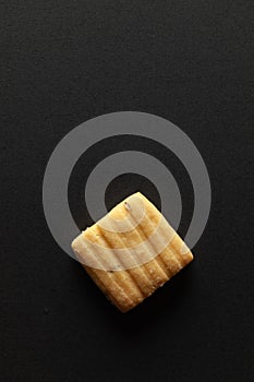 One sweet and salted Cumin cookie or Indian Jeera cookie, on a black background.