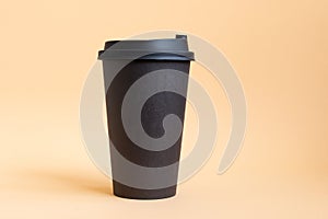 One takeaway black coffee cup on neutral background. Mock-up, nobody, front view, copy space.