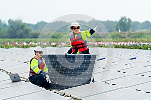 One technician worker sit and look to area that co-worker point to the right and discuss about work of solar cell panel in the