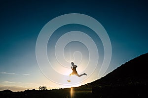 One teenager running alone at the sunset - silhouette of man doing jogging -healthy and fitness lifestyle concept