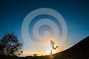 One teenager running and jogging alone in the mountains at the sunset on the rocks - healthy and fitness lifestyle concept - man