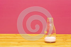 One-third pint milk bottle with dregs of strawberry milkshake