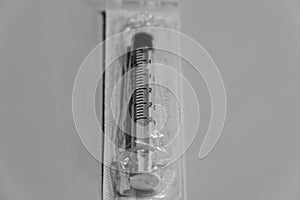 A one time use syringe is still in its package waiting to be used photo