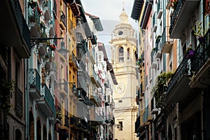 One of the towers of Pamplona Cathedral can be seen from Curia Street with its colourful facades photo