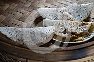 One of the traditional snacks from Tabanan, Bali made from rice flour roasted on a clay stove. Slices of banana and grated coconut