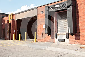 one two receiving bay garage doors next to each other in bright sun in summer. p