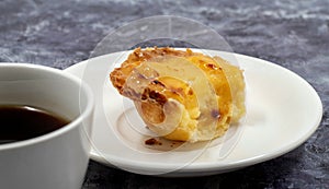 One uneaten Pastel de nata or Portuguese egg dessert on a white plate. Pastel de Belm is a small pie with a crispy puff