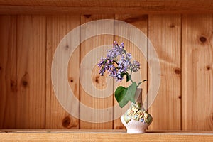 One vase with flowers at wooden background