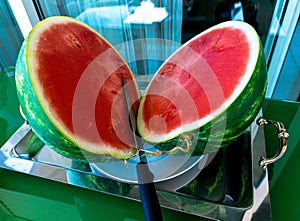 One watermelon cuted in halves on matal tray on glass table