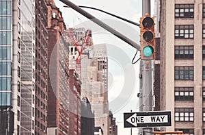 One Way road sign and traffic lights in New York City, color toning applied, selective focus, USA