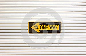 One way sign against a wall background