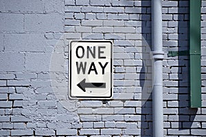 One Way Sign on Brick Wall