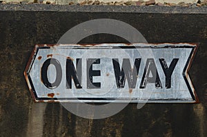 ONE WAY sign on concrete wall