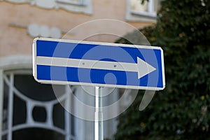 One way street in direction of arrow road sign isolated on black