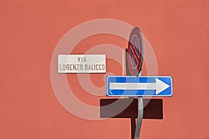 One way traffic sign, traffic road sign, sign with name of the street reading - Via Lorenzo Balicco - stop and parking